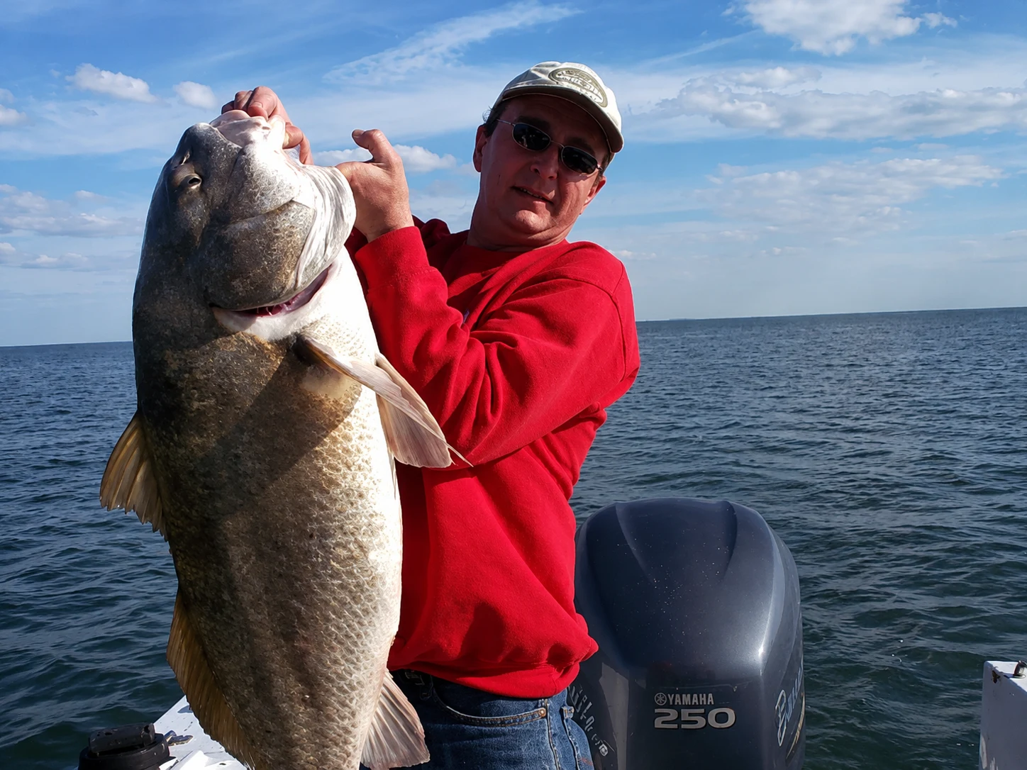 Angler holding a trophy black drum on a fishing charter